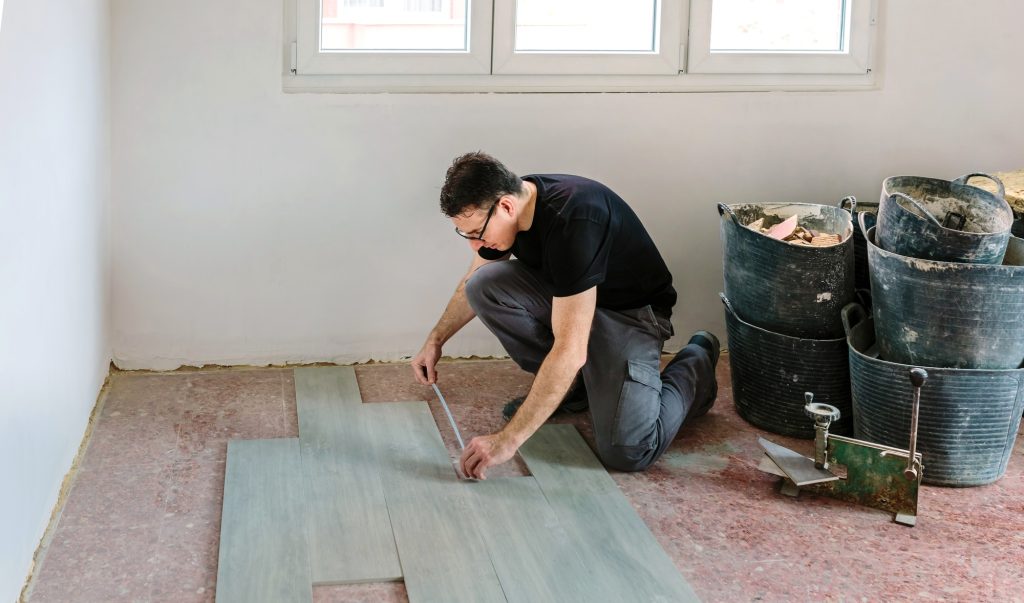 Servicios 1 Bricklayer measuring tiles to install a floor